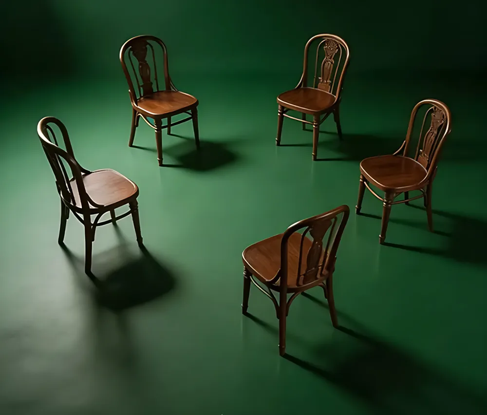 Empty chairs facing different ways on a green floor